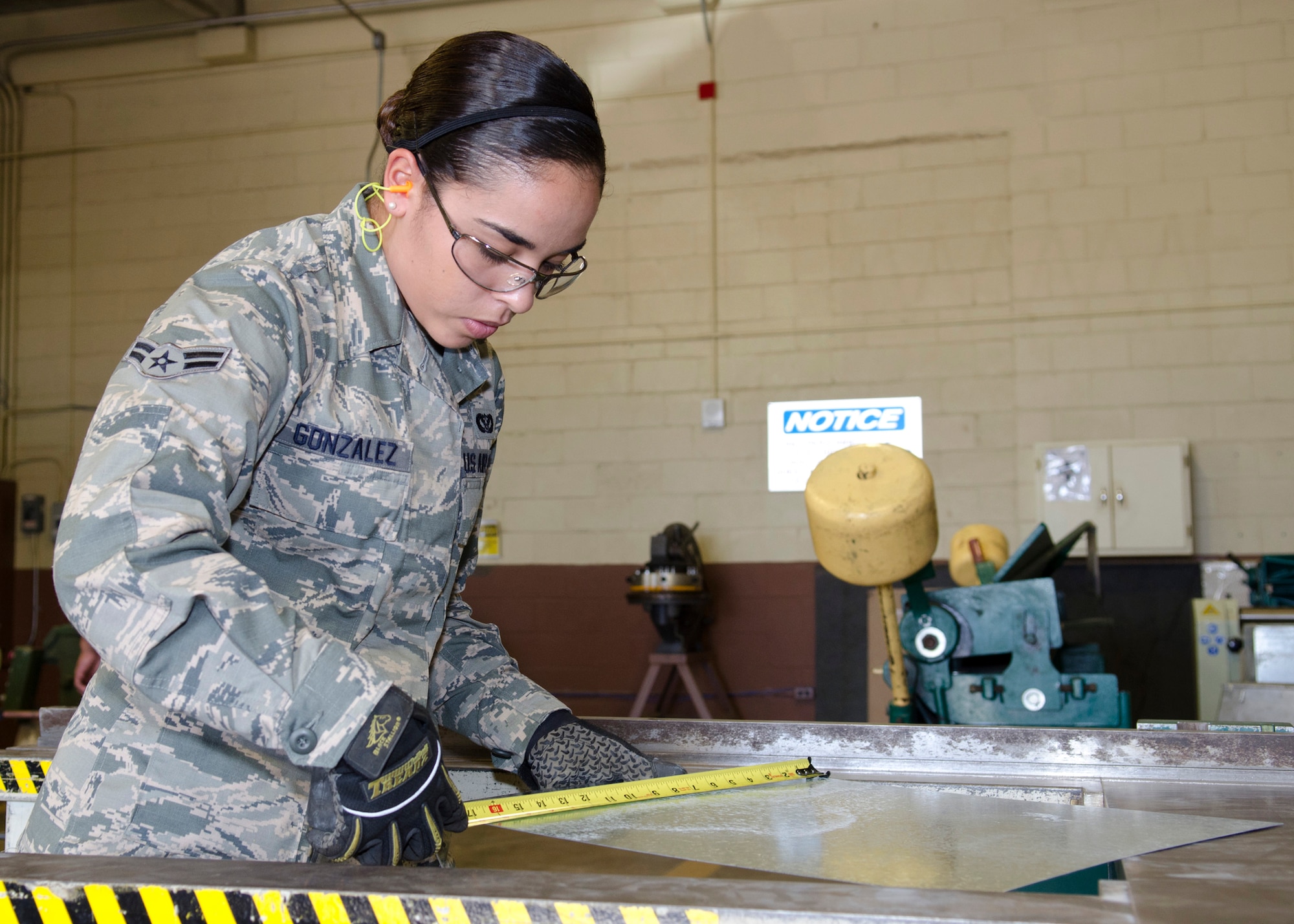 Airman 1st Class Amee Gonzalez, 36th Civil Engineer Squadron structural apprentice, measures a piece of galvanized coated steel March 25, 2014, on Andersen Air Force Base, Guam. Although a structural apprentice receives training in welding, carpentry, locksmithing, masonry and sheet metal work, they are also paired with a civilian counterpart in a specific field to sharpen their skills. (U.S. Air Force photo by Senior Airman Katrina M. Brisbin/Released)