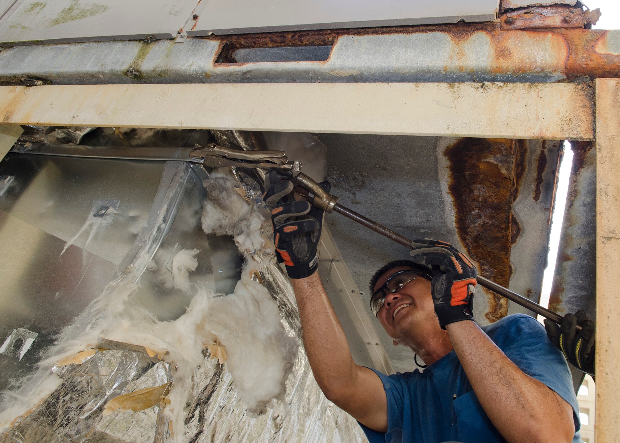 John Camacho, 36th Civil Engineer Squadron sheet metal mechanic, removes a drive slip joint using a slide hammer March 25, 2014, on Andersen Air Force Base, Guam. The current ductwork at building 5104 is being replaced with a newer and more eco-friendly unit. (U.S. Air Force photo by Senior Airman Katrina M. Brisbin/Released)