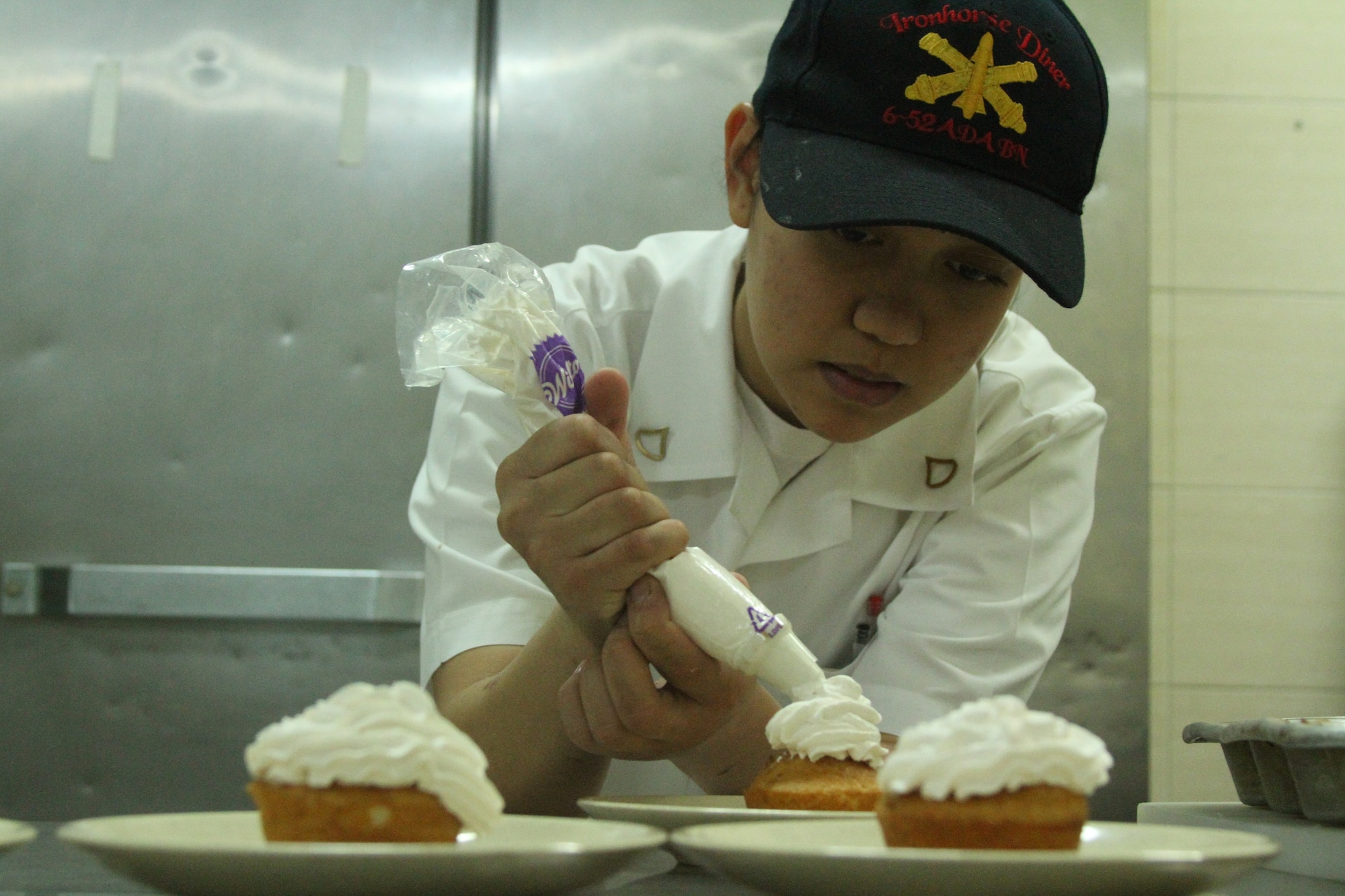Pfc. Julie Ann Flores, a food service specialist assigned to 6-52 Air Defense Artillery Battalion on Suwon Air Base, Republic of Korea, decorates pastries in the Suwon dining facility March 24, 2014. Flores won two bronze medals in the 39th Annual Military Culinary Arts Competition held March 9-13 at Fort Lee, Va. (Photo by: KATUSA Pfc. Shin Young, 6-52 ADA UPAR)