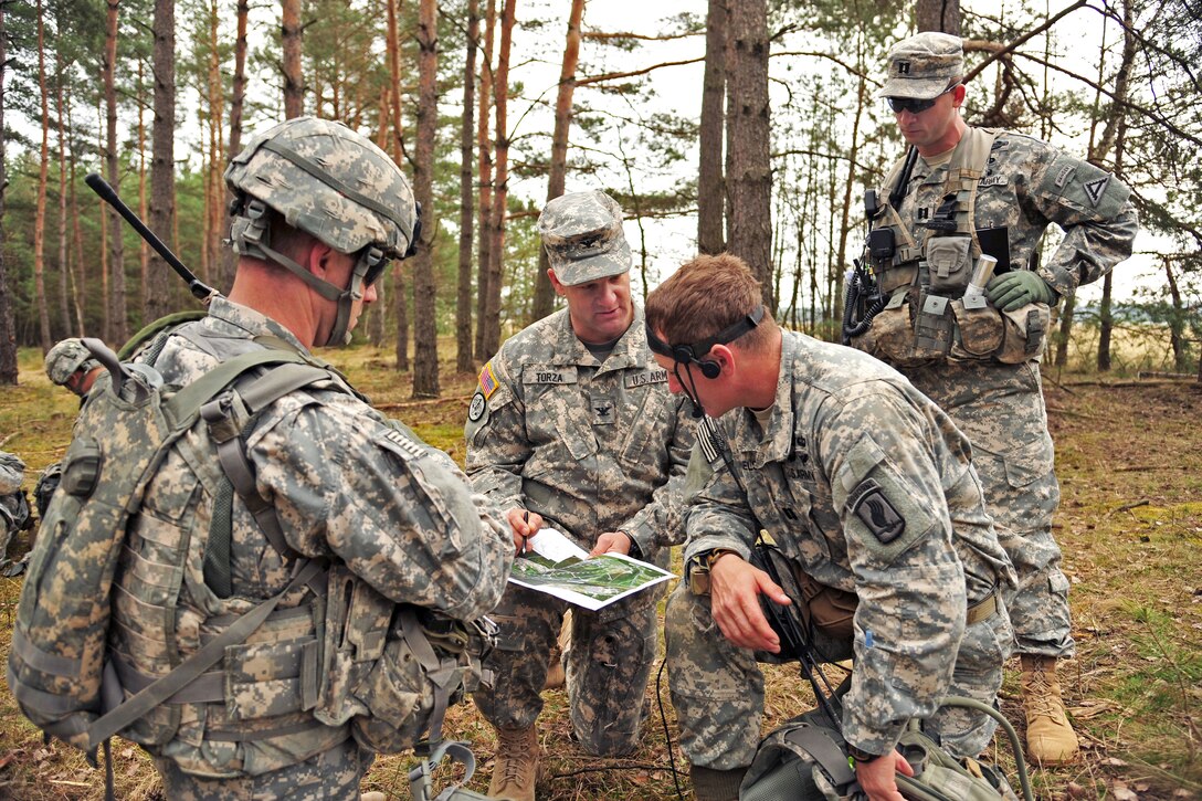 U.S. Army Col. Vincent Torza, center, talks to paratroopers while U.S. Army Cpt. David Cochrane, right, an observer/controller, monitors training during a combined-arms, live-fire exercise at the 7th Army Joint Multinational Training Command's Grafenwoehr and Hohenfels training areas in Germany, March 28, 2014. 