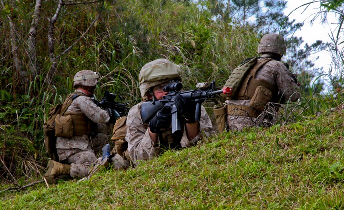 Pfc. Austin J. Baker, center, provides security March 19 during a patrol as part of a field training exercise in the Central Training Area, Okinawa. When the squad reached a path leading off the road, the patrol was halted and a team would clear the area to ensure it was safe. Baker is a law enforcement specialist with Company A, 3rd Law Enforcement Battalion, III Marine Expeditionary Force Headquarters Group, III MEF. 