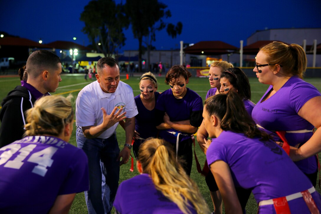Col. Rick Uribe, Marine Aircraft Group 11 commanding officer, leads a spouse team huddle during the Committed and Engaged Spouses Support League “Friday Night Lights” Football Tournament aboard Marine Corps Air Station Miramar, Calif., March 28. A total of nine teams participated in the tournament. 