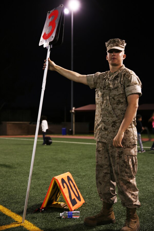 Lance Cpl. Tyler Fields, a seat mechanic with Marine Aviation Logistics Squadron  11, holds the down marker during the Committed and Engaged Spouses Support League “Friday Night Lights” Football Tournament aboard Marine Corps Air Station Miramar, Calif., March 28. Nine teams battled it out on the gridiron for a chance to win the CESSL Friday Night Lights trophy.