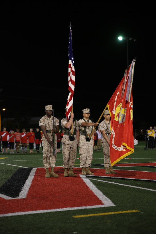 The 3rd Marine Aircraft Wing color guard present the flags during the playing of the National Anthem  before the championship game of the Committed and Engaged Spouses Support League “Friday Night Lights” Football Tournament aboard Marine Corps Air Station Miramar, Calif., March 28. The tournament was intended to develop camaraderie throughout 3rd MAW. 