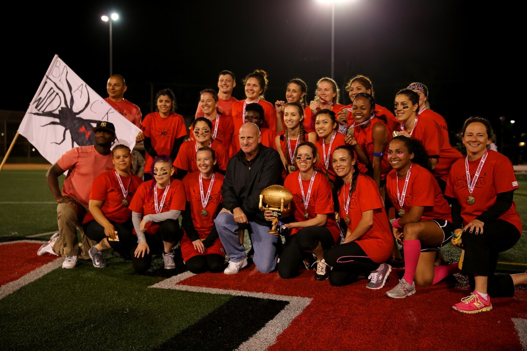 Maj. Gen. Steven Busby, center, 3rd Marine Aircraft Wing commanding general, takes a team photo with Marine Aircraft Group 16 spouses after receiving the Committed and Engaged Spouses Support League “Friday Night Lights” Football Tournament trophy aboard Marine Corps Air Station Miramar, Calif., March 28. Nine teams ranging from Marine Corps Base Camp Pendleton, Calif., to Marine Corps Air-Ground Combat Center Twentynine Palms, Calif., participated in the tournament. 