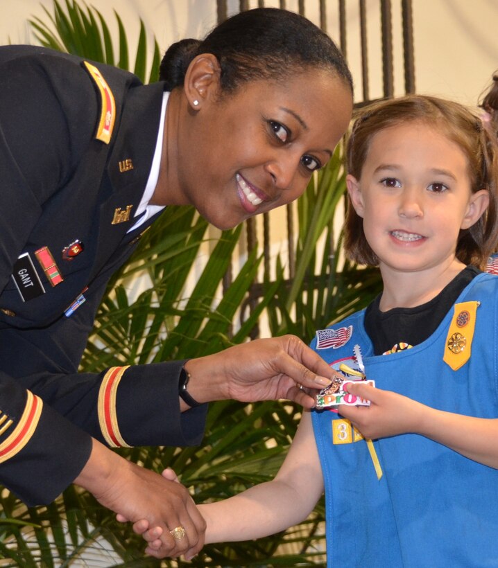 ALBUQUERQUE, N.M., -- District Commander Lt. Col. Gant rewards one of the Girl Scouts with her Owl Prowl badge, March 22, 2014.