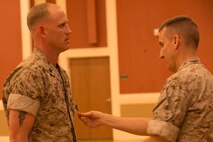 Petty Officer 1st Class Lance S. Wyatt (left), an El Paso, Ark. native, receives the Navy and Marine Corps Commendation Medal with combat distinguishing device from Navy Capt. Rodney Gunning, an Elwood, Ind. Native, and the commanding officer of 2nd Dental Battalion, 2nd Marine Logistics Group, II Marine Expeditionary Force, during an award ceremony aboard Camp Lejeune, N.C., April 2, 2014. Wyatt triaged, treated, and stabilized 32 urgent Afghan National Army, police and civilian casualties, saving numerous lives and significantly preserving combat power during the summer fighting season in Sangin District, Helmand province, Afghanistan, during his 2013 deployment. 
