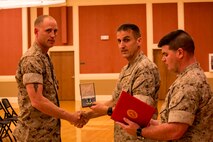 Petty Officer 1st Class Lance S. Wyatt (left) an El Paso, Ark. native, poses for a photo with Navy Capt. Rodney Gunning (center), an Elwood, Ind. Native, and the commanding officer of 2nd Dental Battalion, 2nd Marine Logistics Group, II Marine Expeditionary Force while Command Master Chief Petty Officer Christopher J. Dingler reads Wyatt’s citation during an award ceremony aboard Camp Lejeune, N.C., April 2, 2014. Wyatt received the Navy and Marine Corps Commendation Medal with combat distinguishing device. He triaged, treated, and stabilized 32 urgent Afghan National Army, police and civilian casualties, saving numerous lives and significantly preserving combat power during the summer fighting season in Sangin District, Helmand province, Afghanistan, during his 2013 deployment.