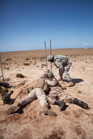 U.S. Marine Corps Lance Cpl. Carlos E. Medina, military policeman, 2nd Law Enforcement Battalion, 2nd Marine Expeditionary Brigade, II Marine Expeditionary Force is the assistant gunner for a member of the Royal Moroccan Armed Forces (FAR) while U.S. Army Spc. Alex M. Cornelius, military policeman, 230th Military Police Company, 95th Military Police Battalion, 18th Military Police Briade clears a M240 B machine gun during a live fire training exercise as part of exercise African Lion 2014 on Tifnit FAR Base in Agadir, Morocco, Mar. 29, 2014. African Lion is conducted as a combined joint exercise between the Kingdom of Morocco and the U.S. Forces to strengthen relationships and military operability in the region. (U.S. Marine Corps Photo by Cpl. Alexandria Blanche, 2D MARDIV COMCAM/Released)