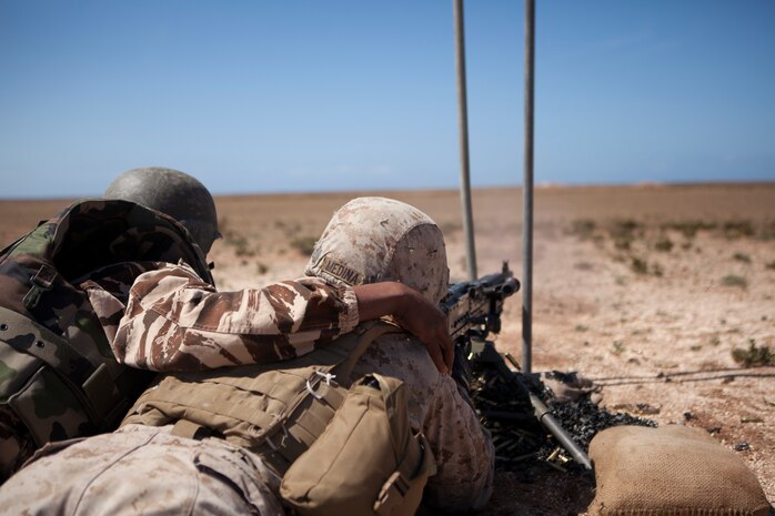 A member of the Royal Moroccan Armed Forces (FAR) is the assistant gunner for U.S. Marine Corps Lance Cpl. Carlos E. Medina, military policeman, 2nd Law Enforcement Battalion, 2nd Marine Expeditionary Brigade, II Marine Expeditionary Force firing a M240B machine gun during a live fire training exercise as part of exercise African Lion 2014 on Tifnit FAR Base in Agadir, Morocco, Mar. 29, 2014. African Lion is conducted as a combined joint exercise between the Kingdom of Morocco and the U.S. Forces to strengthen relationships and military operability in the region. (U.S. Marine Corps Photo by Cpl. Alexandria Blanche, 2D MARDIV COMCAM/Released)