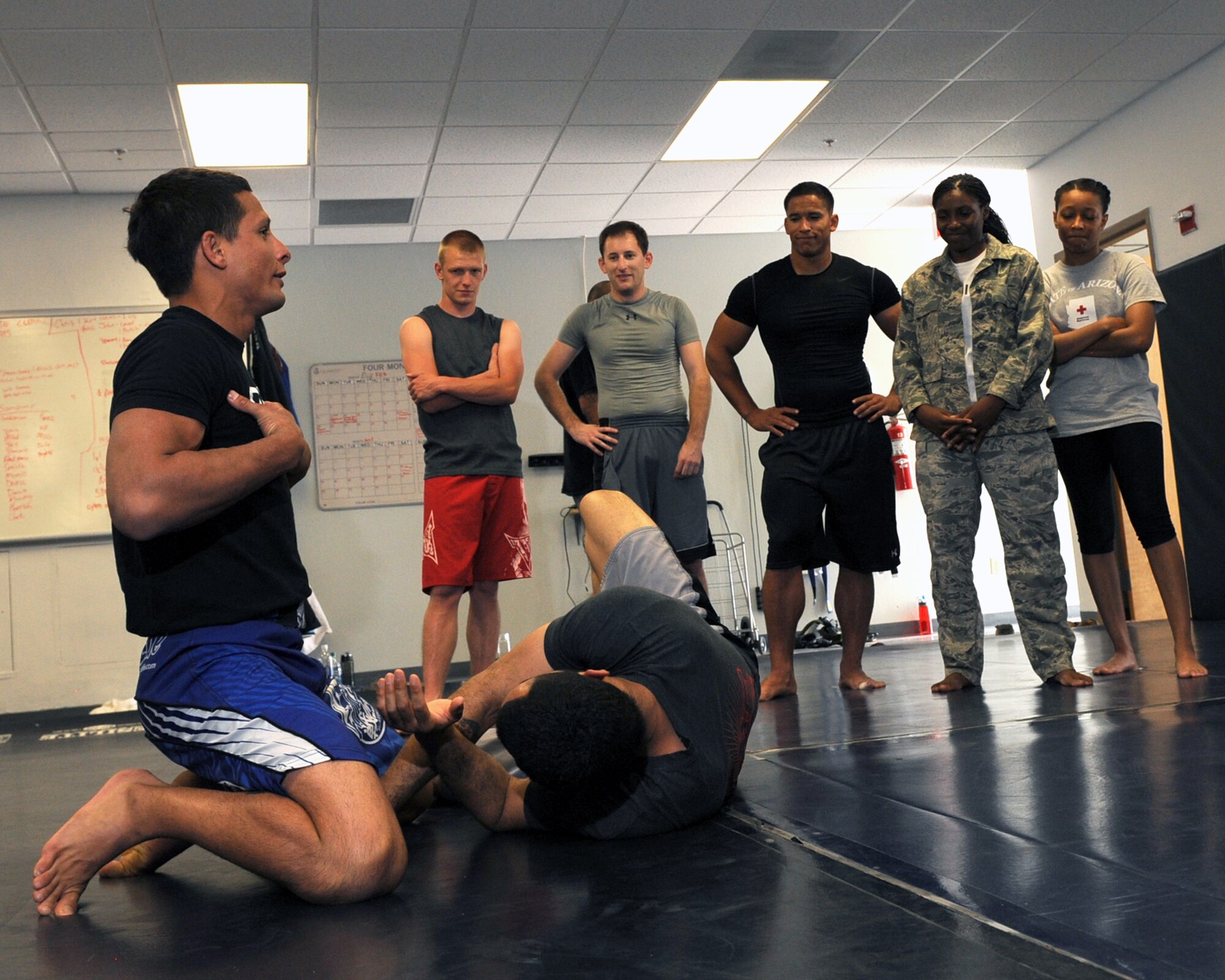 Anthony Birchak, the Maximum Fighting Championship Bantamweight World Champion, instructs Airmen on combatives during a seminar at Davis-Monthan Air Force Base, Ariz., March 30, 2014. Birchak teaches his technique in a backward style to give his pupils a clear visual of how to defeat their adversaries. (U.S. Air Force photo by Airman 1st Class Chris Drzazgowski/Released)