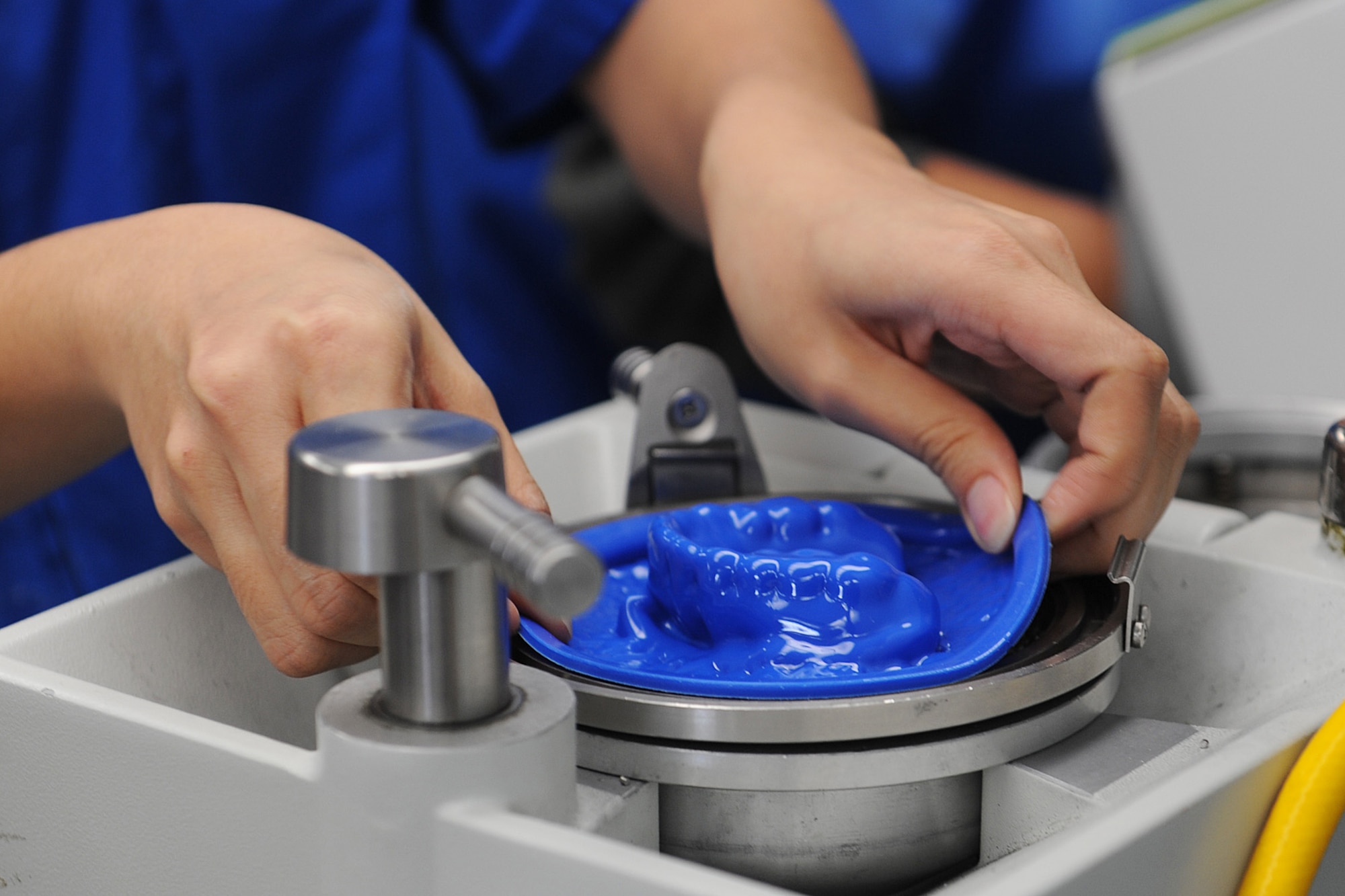 Senior Airman Jorgette Chuang molds a plastic mouth guard on a vacuum former at Scott Air Force Base, Ill., Feb. 19, 2014.  Chuang makes the mouth guard by heating the mouth guard material and inverting it to the cast and vacuuming out all the air, so that the plastic will take the shape of the cast.   Chuang is a 375th Dental Squadron dental laboratory technician.  (U.S. Air Force photo by Staff Sgt. Maria Bowman)