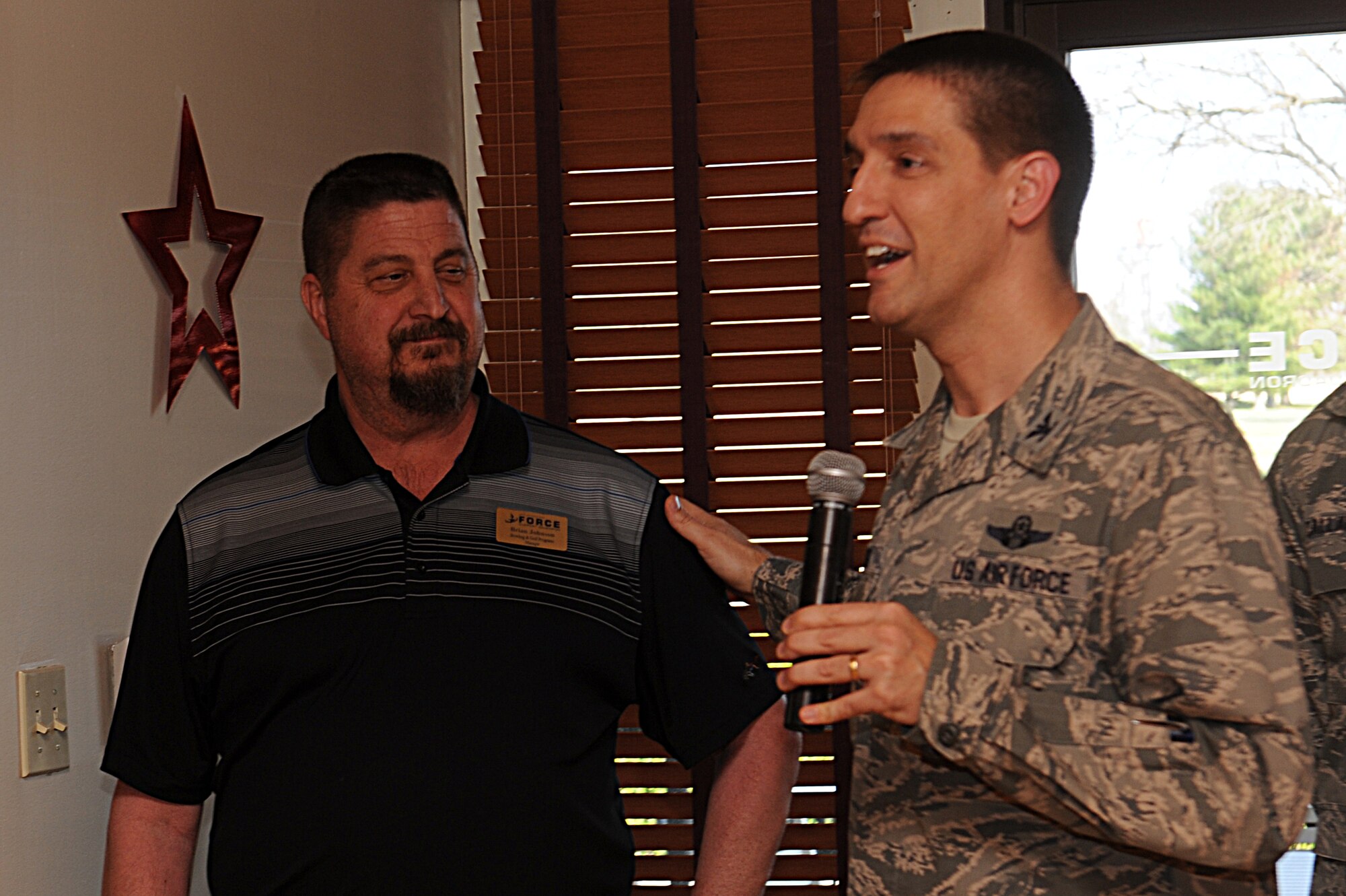 Col. Kyle Kremer, 375th Air Mobility Wing commander, thanks Brian Johnson, the 375th Force Support Squadron bowling and golf programs manager, during a celebration re-opening of the golf course March 28.