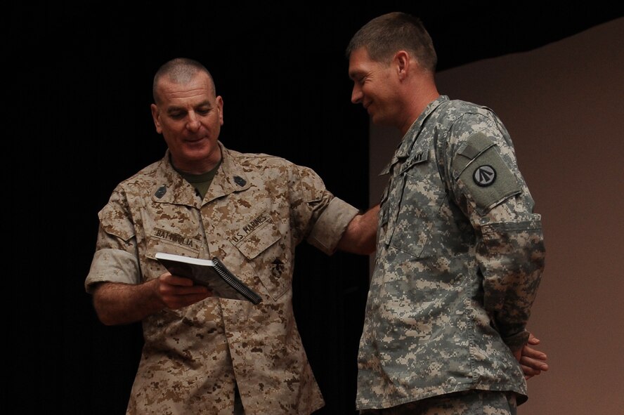 Marine Sgt. Maj. Bryan Battaglia awards a Soldier with a signed copy of his book for asking him a great question at the Library Auditorium, March 28, 2014, Scott Air Force Base, Ill. Battaglia spoke about his book, "The Noncommissioned Officer and Petty Officer: The Backbone of the Armed Forces," and also answered questions from servicemembers. Battaglia is the Senior Enlisted Advisor to the Chairman of the Joint Chiefs of Staff. (U.S. Air Force photo/Airman 1st Class Megan Friedl)