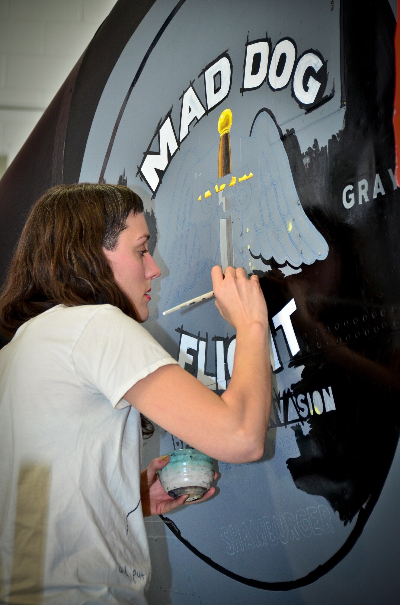 Students and directors from the University of Alabama-Birmingham paint nose art on a KC-135R aircraft. The design commemorates the 117th Air Refueling Wing's participation in the 1961 Bay of Pigs operation. Tech. Sgt. Aaron Sharit, a crew chief from the 117th Maintenance Group, created the design and was inspired by a combination of logos and graphics that were used on some of the aircraft during the invasion.  (U.S. Air National Guard photo by Master Sgt. Ken Johnson/Released)