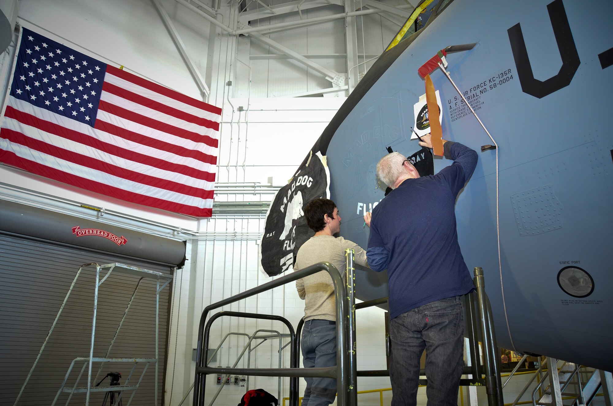 Students and directors from the University of Alabama-Birmingham paint nose art on a KC-135R aircraft. The design commemorates the 117th Air Refueling Wing's participation in the 1961 Bay of Pigs operation. Tech. Sgt. Aaron Sharit, a crew chief from the 117th Maintenance Group, created the design and was inspired by a combination of logos and graphics that were used on some of the aircraft during the invasion.  (U.S. Air National Guard photo by Master Sgt. Ken Johnson/Released)