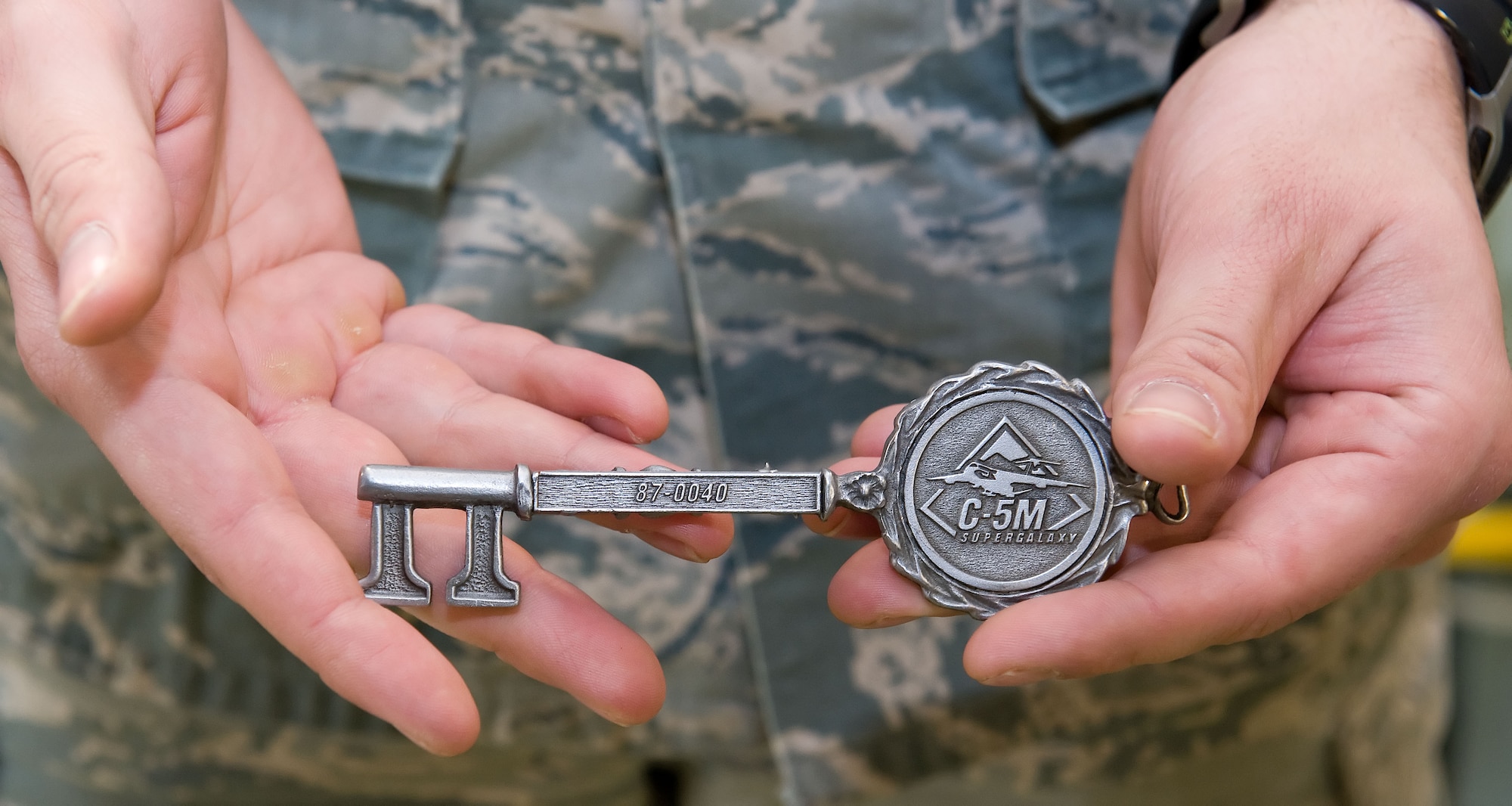 Senior Airman Bradley Harris, 436th Aircraft Maintenance Squadron dedicated crew chief, holds the ceremonial aircraft key to C-5M Super Galaxy tail number 87-0040 April 2, 2014, at Dover Air Force Base, Del. Team Dover received its 18th C-5M Super Galaxy, which completes Team Dover's fleet. (U.S. Air Force photo/Roland Balik)