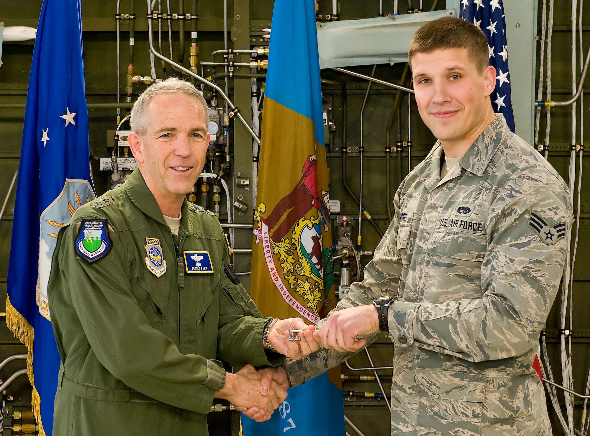 Lt. Gen. Brooks L. Bash, Air Mobility Command vice commander, left, presents Senior Airman Bradley Harris, 436th Aircraft Maintenance Squadron dedicated crew chief, right, the ceremonial aircraft key for Team Dover's 18th C-5M Super Galaxy, tail number 87-0040 April 2, 2014, at Dover Air Force Base, Del. As dedicated crew chief, Harris will be responsible for its maintenance, servicing and mission readiness. (U.S. Air Force photo/Roland Balik)