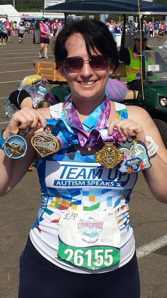 Kari Schwendenman, spouse of U.S. Air Force Staff Sgt. Brandon Schwendenman, holds up medals after completing the glass slipper challenge in Orlando, Fla., Feb. 23, 2014. Schwendenman ran the challenge for an organization that raises money for families with an autistic child. (courtesy photo) 
