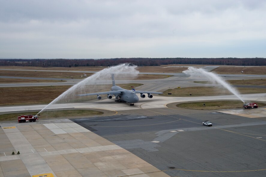 Fire trucks from the 436th Civil Engineer Squadron Fire Department give C-5M Super Galaxy 87-0040 and aircrew a customary spray-down as it pulls into a parking spot after its arrival to Dover Air Force Base, Del., on April 2, 2014. The addition of this aircraft makes DAFB the first base with a complete C-5M fleet. (U.S. Air Force photo/Staff Sgt. Elizabeth Morris)