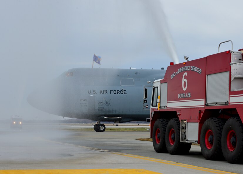 Fire trucks from the 436th Civil Engineer Squadron spray down a C-5M Super Galaxy as it arrives April 2, 2014, at Dover Air Force Base, Del. The delivery of the C-5M Super Galaxy marks the completion of Team Dover’s fleet with a total of 18 C-5M aircraft. (U.S. Air Force photo/Airman 1st Class William Johnson)