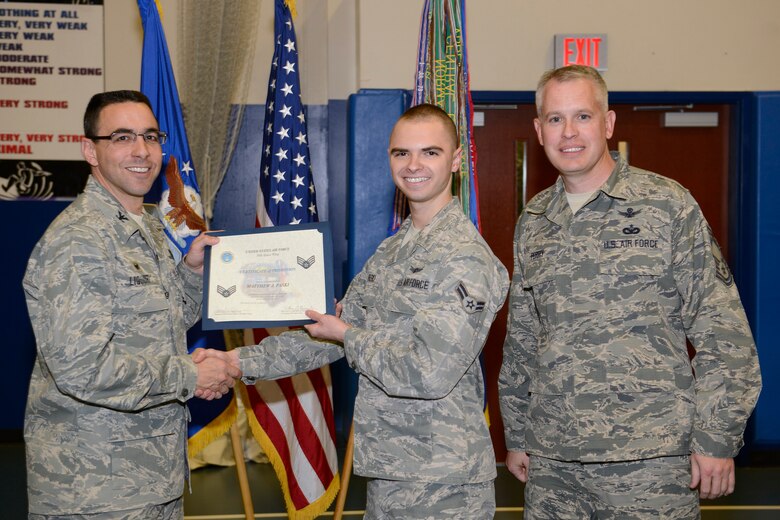 Col. Bill Liquori (left), 50th Space Wing commander, and Chief Master Sgt. Douglas Perry, 50th Operations Group superintendent, present a promotion certificate to Airman 1st Class Matthew Paski (center), 2nd Space Operations Squadron, after being selected for a Senior Airman Below the Zone promotion during a ceremony March 31, 2014, at Schriever Air Force Base, Colo. The below-the-zone promotion aims to provide an opportunity for exceptionally well qualified airmen first class a one-time consideration for promotion to senior airman. (U.S. Air Force photo/Christopher DeWitt)