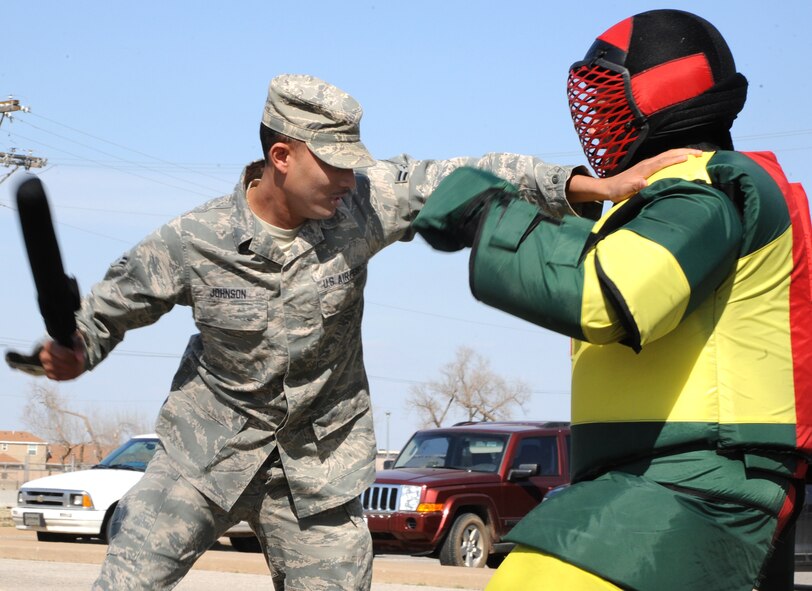 Airman 1st Class Torrance Johnson, a 71st Force Support Squadron customer support technician, shoves back his instructor and moves to strike with a practice baton during security forces augmentee training March 24 at Vance Air Force Base, Okla. Baton training is one of the culminating events before augmentees are certified to support security forces during emergency operations. Each year, the 71st SFS trains 24 Airmen from different squadrons across Vance to bolster their numbers in case of emergency. (U.S. Air Force photo/Senior Airman Frank Casciotta)