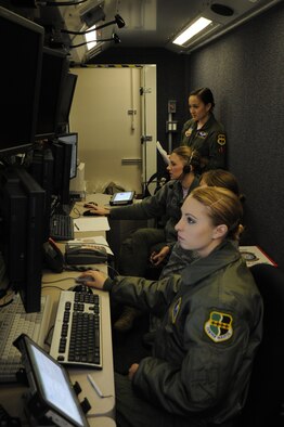 Members of the 348th Reconnaissance Squadron monitor the flight of an RQ-4 Global Hawk during an endurance flight from Grand Forks Air Force Base, N.D., March 28, 2014. The flight set a new record, lasting 34.3 hours. Additionally, the mission was staffed entirely by female Airmen in recognition of Women's History Month. (U.S. Air Force photo illustration/Staff Sgt. David Dobrydney)
