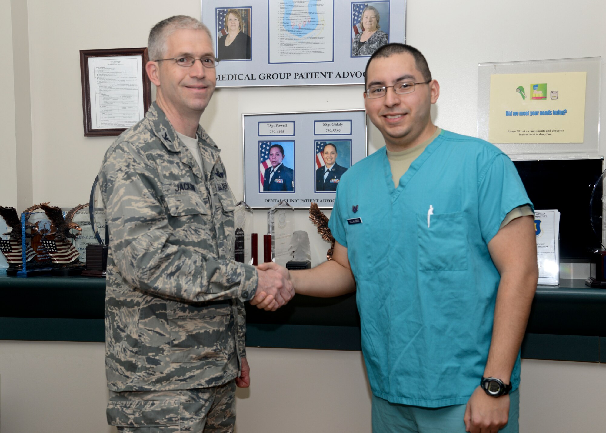 Col. Joel Jackson, 22nd Air Refueling Wing commander, shakes hands with Staff Sgt. Gabriel Villalobos, 22nd Aerospace Medicine Squadron dental technician, April 1, 2014, at McConnell Air Force Base, Kan. Villalobos was awarded a commander’s coin for his outstanding performance as a supervisor. (U.S. Air Force photo/Airman 1st Class John Linzmeier)