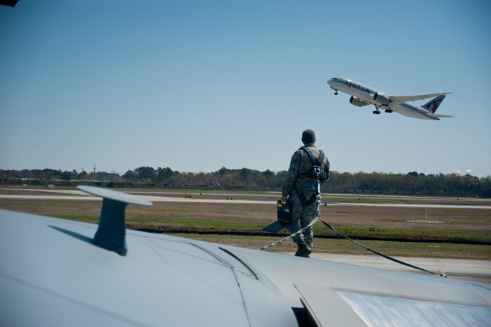 Senior Airman John Burke, 437th Aircraft Maintenance Squadron crew chief, performs maintenance on top of a C-17 Globemaster III, March 26, 2014, at Joint Base Charleston, S.C. The large formation exercise provided more than 500 operational and maintenance training objectives and demonstrated the U.S. Air Force's strategic capability. (U.S. Air Force photo/ Staff Sgt. William A. O’Brien)