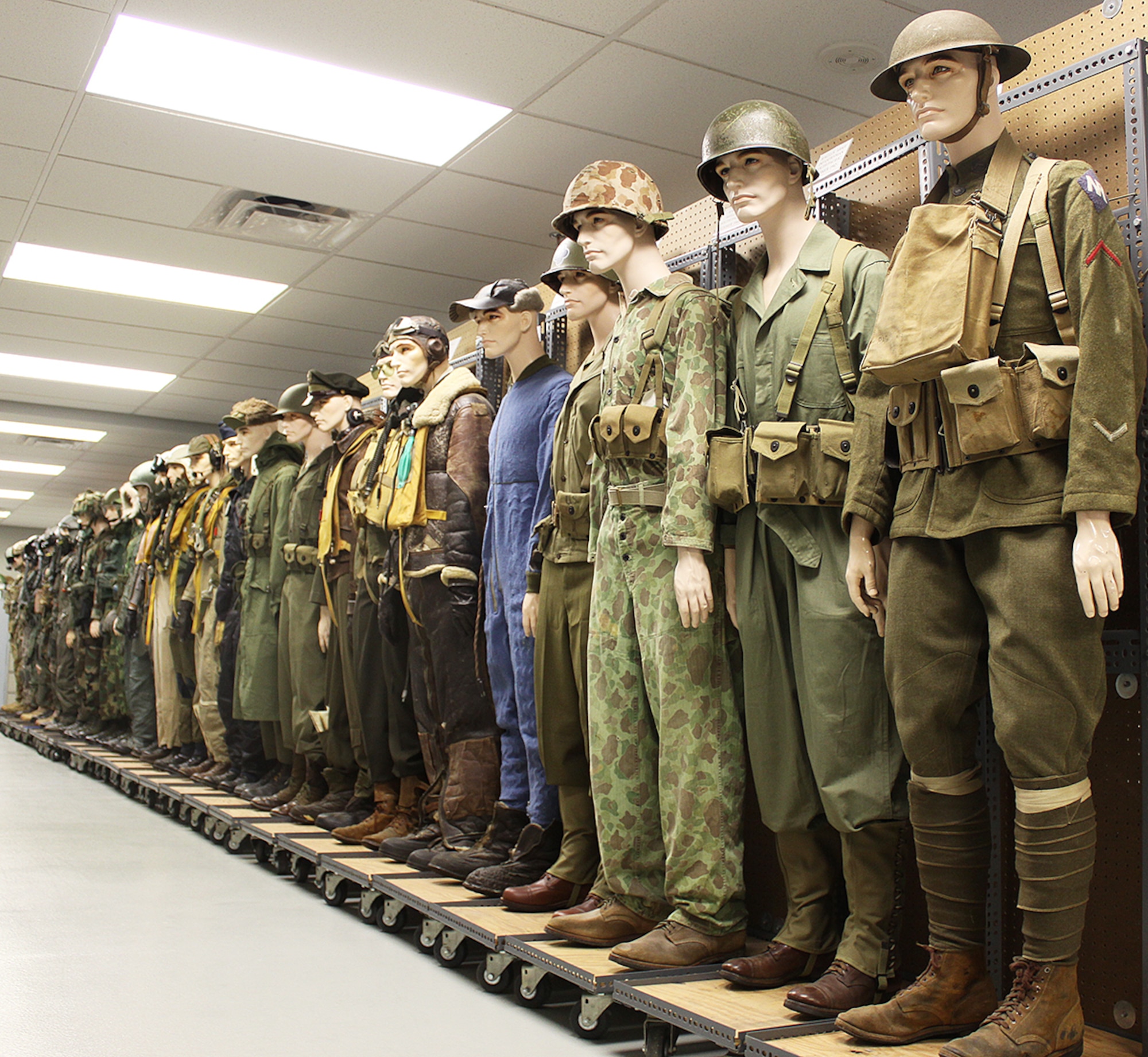 In the Life Science Equipment Laboratory, a row of uniformed mannikens represents all of the eras of accurate uniforms Agile Combat Support keeps on hand for their analysis and forensic-type research.