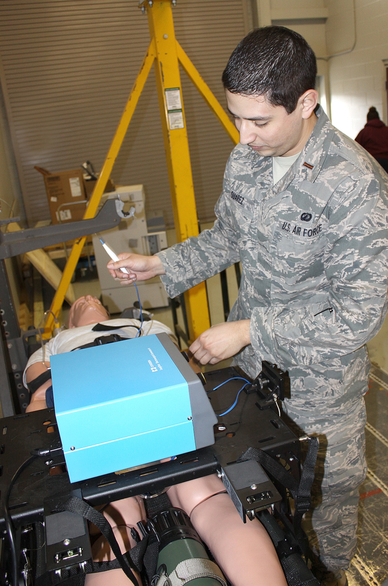 Second Lt. Carlos Suarez ll, a test engineer, demonstrates how an electrical surgical generator cauterizes wounds and blood vessels and allows for in-flight surgery.