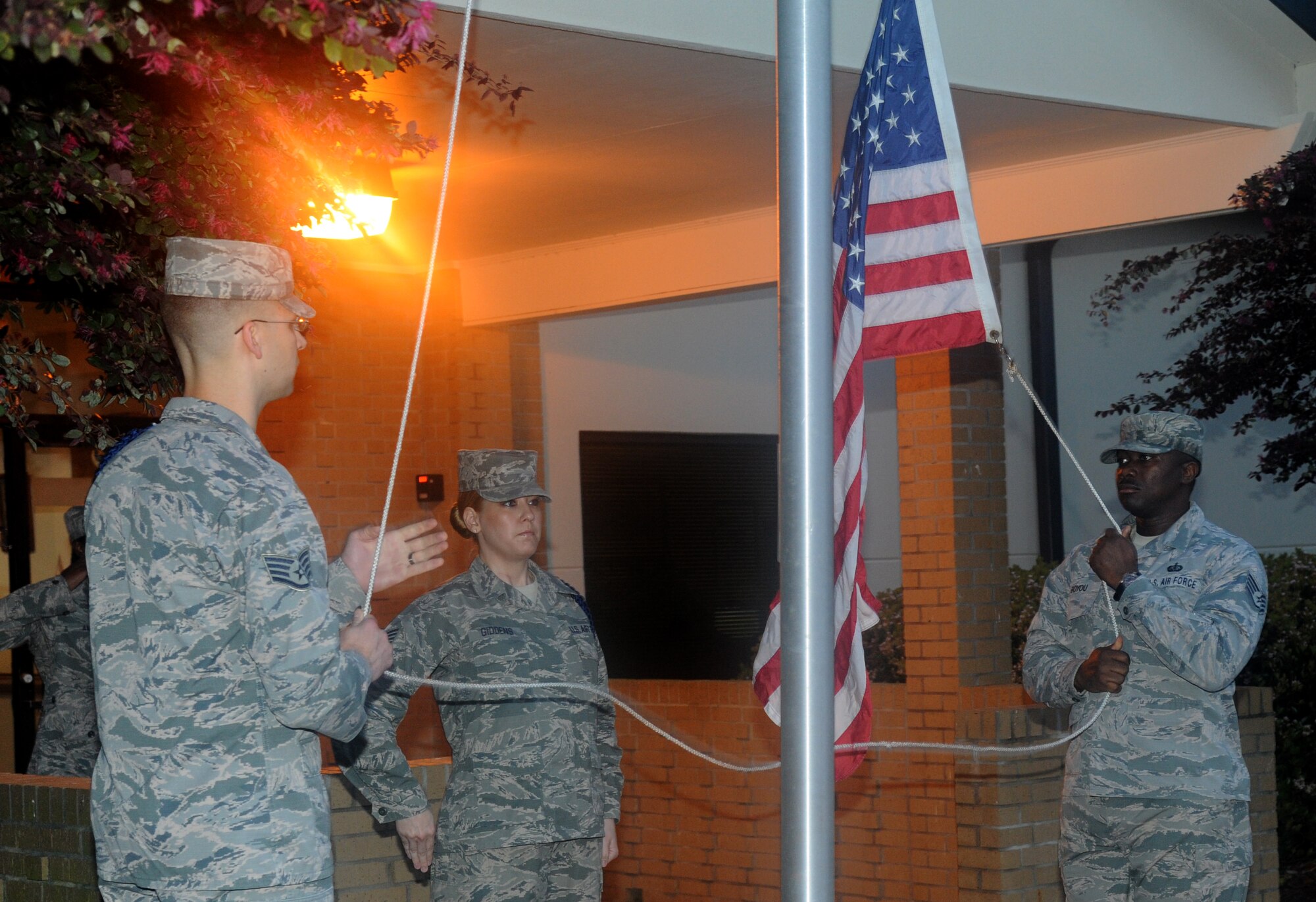 Staff Sgt. Micah Blanton, Tech. Sgt. Joleen Giddens and Staff Sgt. Joseph Boyou, 2nd Air Force, prepares to raise the flag during revile April 2, 2014, in front of 2nd AF headquarters, Keesler Air Force Base, Miss.  The 602nd Training Group (Provisional) conducts an 84-mile 2-day ruck march, which began on Keesler and will end at Camp Shelby Army Post, Miss., to commemorate the 602nd TRG (P) mission in support of Joint Expeditionary Taskings and to their students who made the ultimate sacrifice. (U.S. Air Force photo by Kemberly Groue)