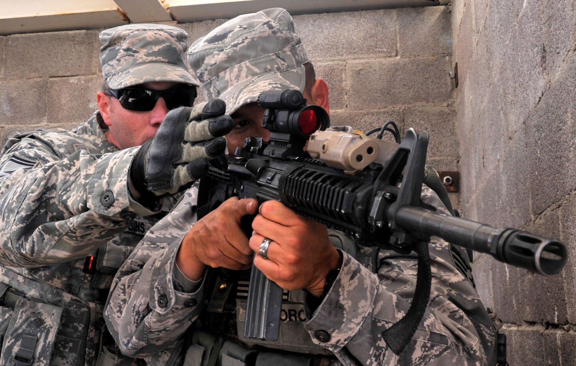 Senior Master Sgt. James Robbins checks an Airman's firing position while clearing a  building March 5, 2014, at Silver Flag Alpha, 99th Ground Combat Training Squadron Range, Nev. Robbins was nominated for the 12 Outstanding Airman of the Year Award and is the 99th GCTS superintendent of operations. (U.S. Air Force photo by Airman 1st Class C.C.)