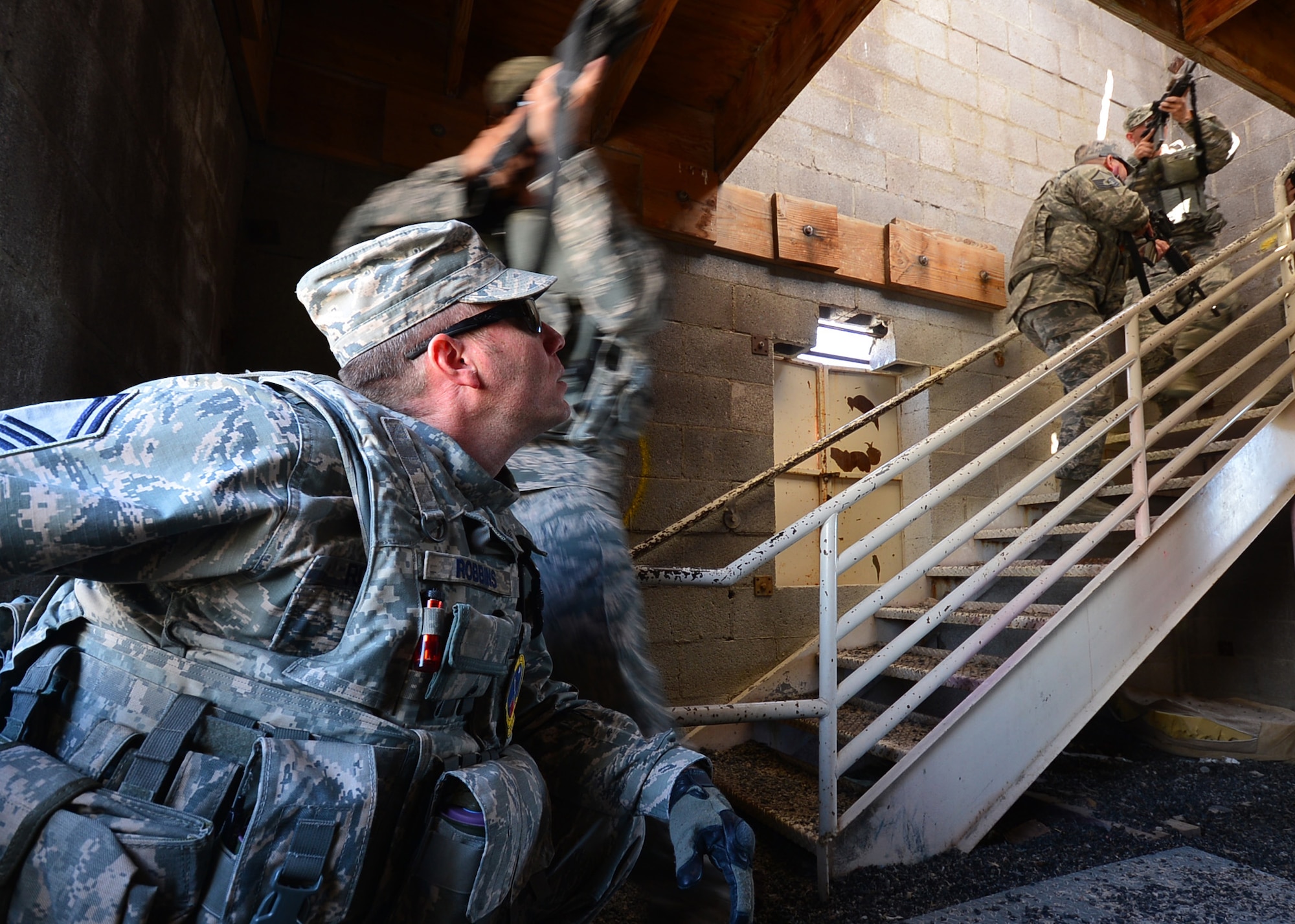 Senior Master Sgt. James Robbins observes his fire team during a stairwell clearing exercise March 5, 2014, at Silver Flag Alpha, 99th Ground Combat Training Squadron Range, Nev. Robbins is a 99th GCTS instructor and superintendent of operations. (U.S. Air Force photo by Staff Sgt. N.B/Released)