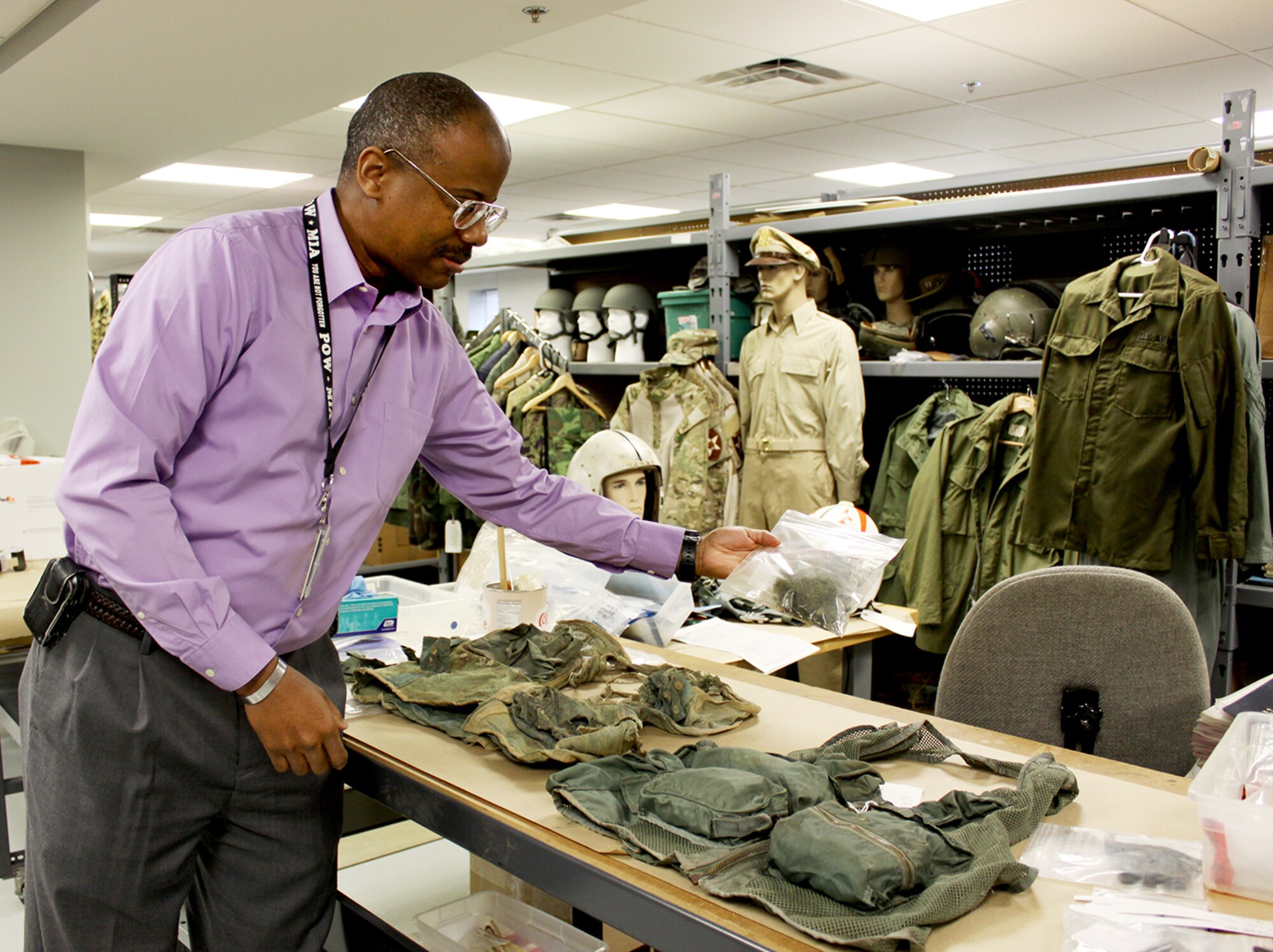 In the Life Science Equipment Laboratory (LSEL), John Goines, LSEL chief, compares a tattered survival vest recovered from the crash of an A-26 in Loas in 1968 with an intact vest from the same time period to determine the survivability of the crash and whether other forensic-type clues can be discerned.