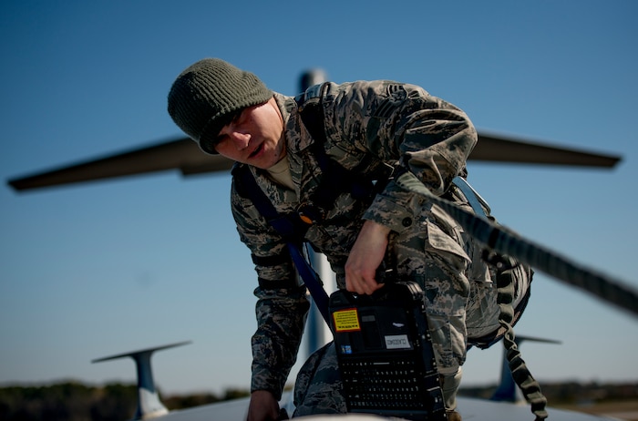 Senior Airman John Burke, 437th Aircraft Maintenance Squadron crew chief, walks the length of A C-17 Globemaster III performing visible checks for damage prior to a large formation exercise March 25, 2014, at Joint Base Charleston, S.C. The large formation exercise provided more than 500 operational and maintenance training objectives and demonstrated the U.S. Air Force's strategic capability. (U.S. Air Force photo/ Senior Airman Dennis Sloan)