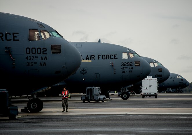 A 437th Aircraft Maintenance Squadron crew chief walks past a row of C-17 Globemaster III aircraft used during the large formation exercise March 27, 2014, at Joint Base Charleston, S.C.  The large formation exercise provided more than 500 operational and maintenance training objectives and demonstrated the U.S. Air Force's strategic capability. (U.S. Air Force photo/ Senior Airman Dennis Sloan)