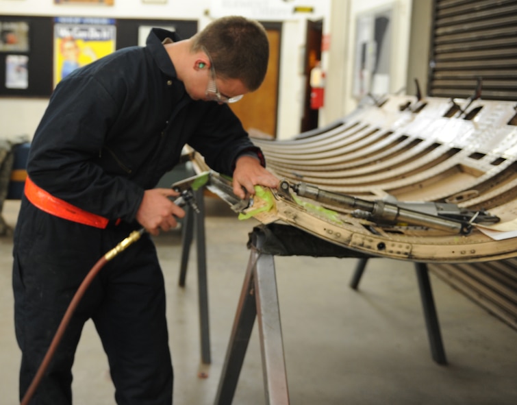 U.S. Air Force Airman 1st Class Joshua Elkins, 7th Equipment Maintenance Squadron aircraft structural maintenance, repairs a section of a B-1B Lancer cowling door March 26, 2014, at Dyess Air Force Base, Texas. By cutting out this portion of the cowling door and replacing it, the Air Force saved $505,000 in supply procurement costs by not having to buy a completely new door. (U.S. Air Force photo by Airman 1st Class Autumn Velez/Released)