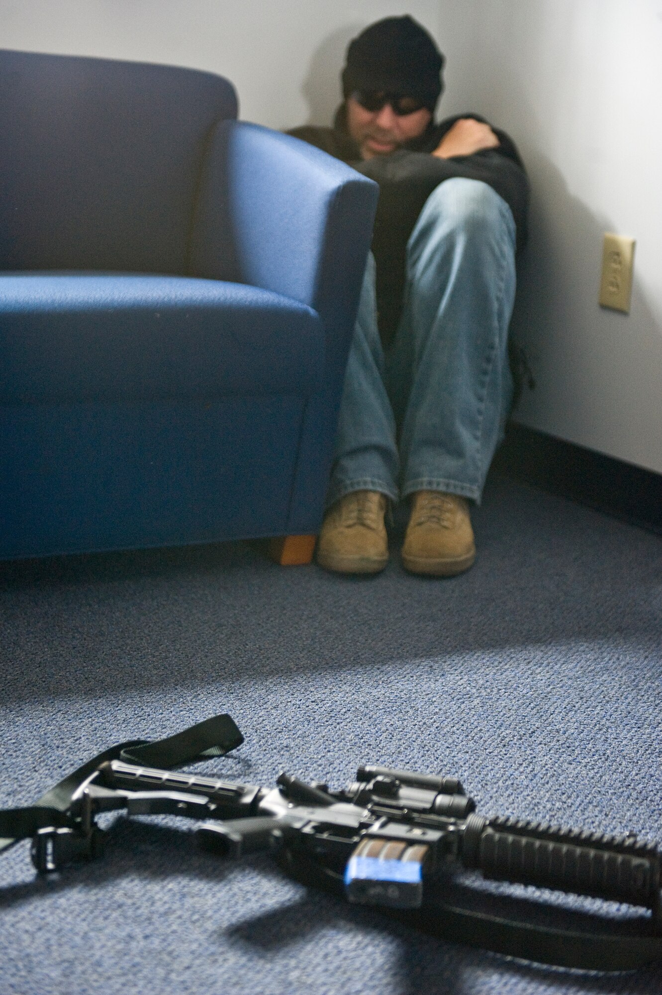William Anderson, 4th Security Forces Squadron training manager, sits away from his weapon during an active shooter exercise, March 28, 2014, at Seymour Johnson Air Force Base, N.C.  Anderson played the role of the active shooter during the exercise and surrendered after shooting multiple simulated victims.  (U.S. Air Force photo/Airman 1st Class Brittain Crolley)