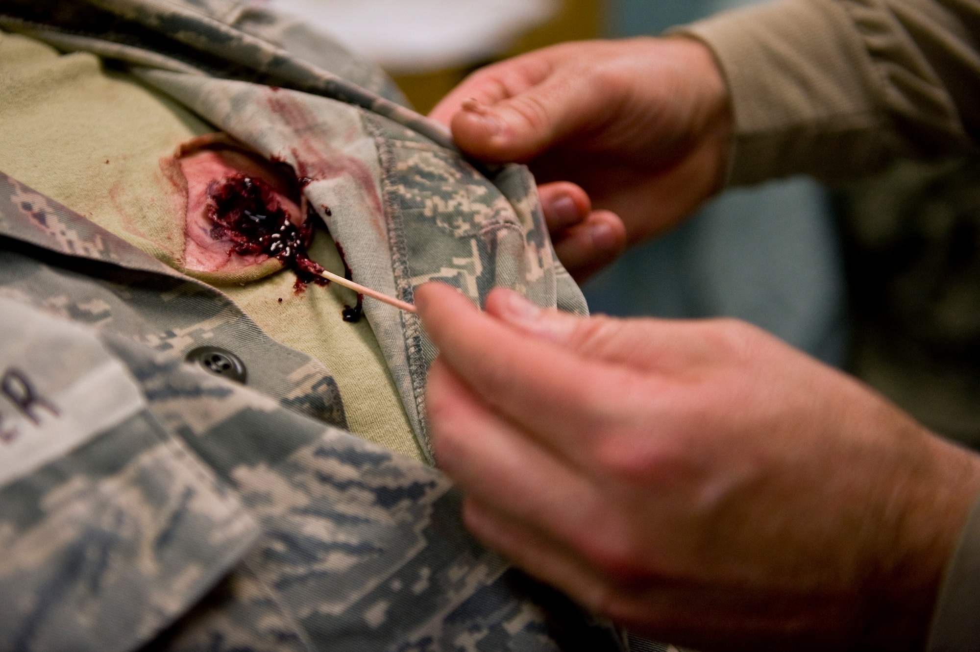 Master Sgt. Jeffrey Vicars, 4th Aerospace Medicine Squadron superintendent, applies costume makeup to a simulated victim before an active shooter exercise, March 28, 2014, at Seymour Johnson Air Force Base, N.C. Mock victims were given simulated wounds to promote realism and test first responders’ capabilities to react under duress.  (U.S. Air Force photo/Airman 1st Class Brittain Crolley)