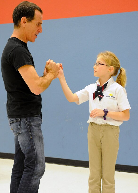 Trevor Romain, award- winning author, speaks with Riley Pickler, a 3rd grade student during a visit to the Imagine Andrews Public Charter School on Joint Base Andrews, Md., March 26 as part of the 2014 “With You All The Way” Tour. The tour is in partnership with The Trevor Romain Group and the United Services Organizations (USO) to promote resiliency for children. (U.S. Air Force photo by Aimee Fujikawa)