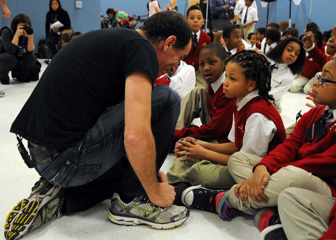 Trevor Romain, award-winning author, speaks with a student during a visit to Imagine Andrews Public Charter School at Joint Base Andrews, Md., March 26 as part of the 2014 “With You All The Way” Tour. The Trevor Romain Group and the United Services Organizations (USO) promote resiliency for children. (U.S. Air Force photo by Aimee Fujikawa)