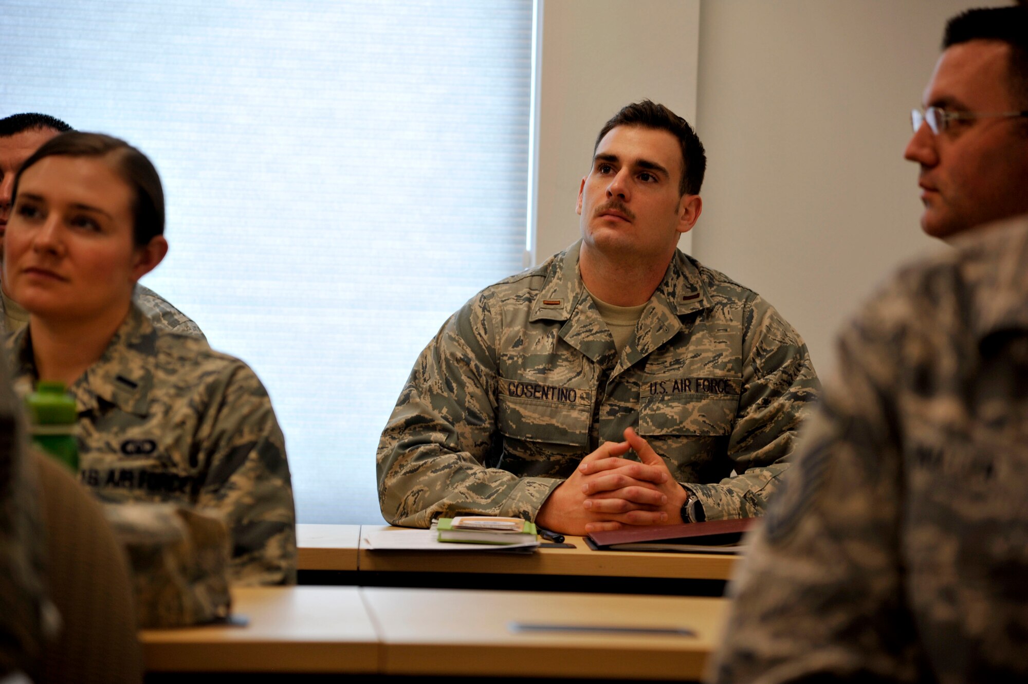 2nd Lt. Anthony Cosentino, 47th Medical Operations Squadron Aerospace and Operational Physiology officer-in-charge, listens to remarks during the First Sergeant Additional Duty Course graduation ceremony at the Student Activities Center on Laughlin Air Force Base, March 20, 2014. The inclusion of company grade officer’s in the course provided them with an idea of the challenges their enlisted Airmen face and set to provide them with gained knowledge of the roles of the enlisted force leadership. (U.S. Air Force photo/Staff Sgt. Steven R. Doty/Released)