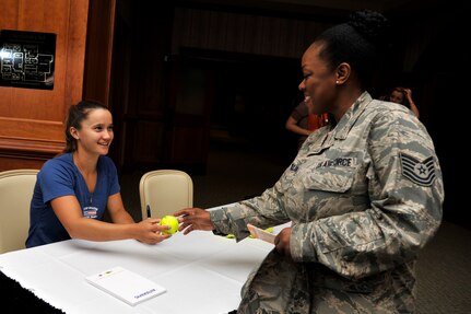 Professional tennis player Lauren Davis, gives an autographed tennis ball to Tech. Sgt. Crystal Collins, a career development professional with the 315th Force Support Squadron, during a morale tour of Joint Base Charleston, S.C. April 1, 2014. The tour included signing autographs at the Charleston Club followed by a C-17A Globemaster III static tour. (U.S. Air Force photo/Staff Sgt. Renae Pittman)