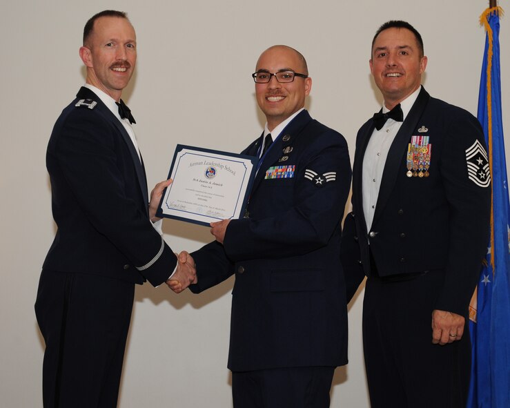Senior Airman Justin Jessick, 2nd Civil Engineer Squadron, receives an Airman Leadership School graduation certificate from Col. Leland Bohannon, 2nd Bomb Wing vice commander, during the ALS Class 14-3 Graduation on Barksdale Air Force Base, La., March 27, 2014. (U.S. Air Force photo/Senior Airman Benjamin Gonsier)
