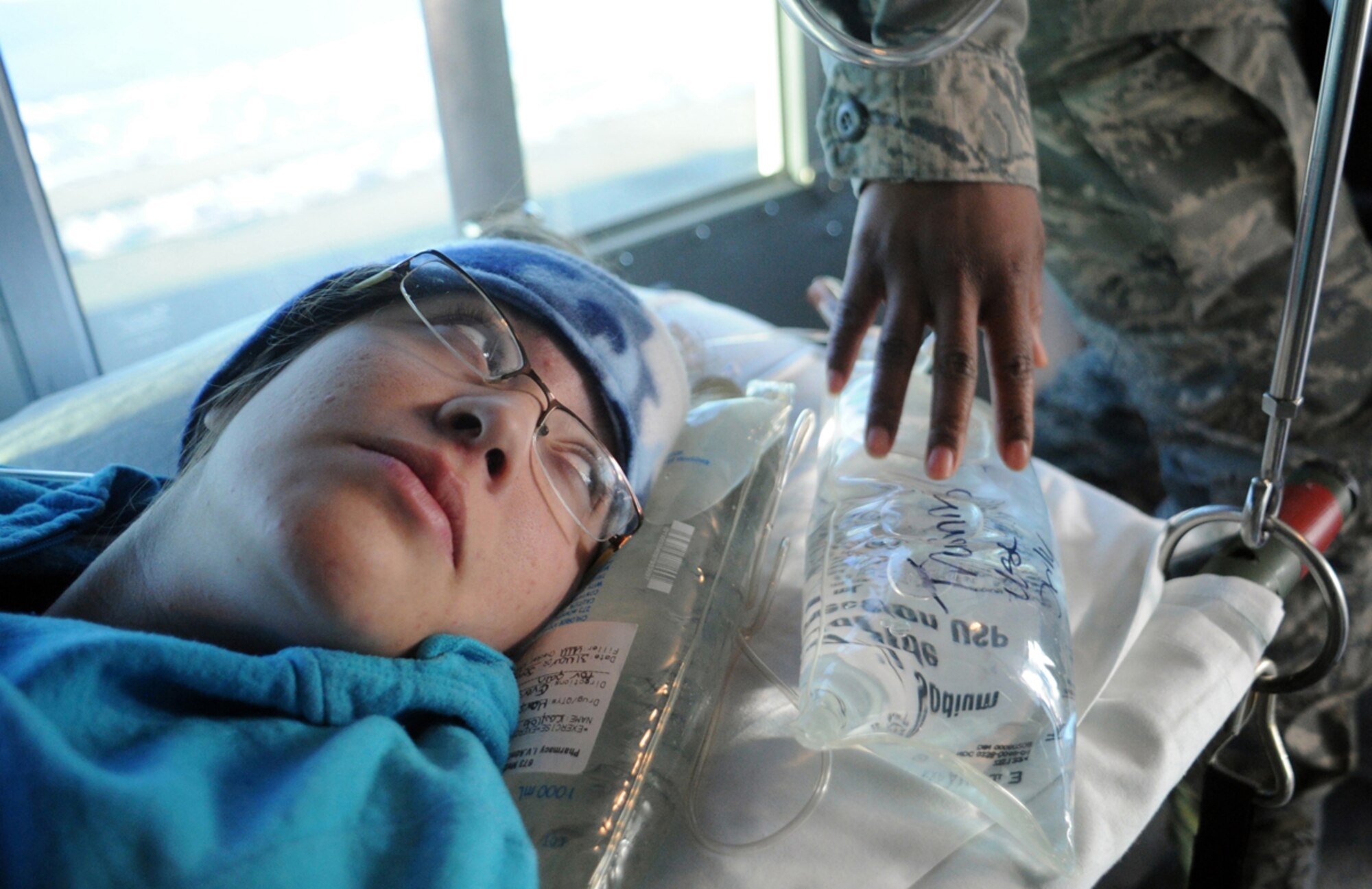 A simulated natural disaster casualty looks at an Airman from the 673d Medical Group holding medical supplies during an evacuation drill as part of Mission Assurance Exercise 14-3 at Joint Base Elmendorf-Richardson, Alaska, March 31, 2014. MAE 14-3 is a JBER exercise testing the base’s ability to survive, operate and coordinate during a major natural disaster.   (U.S. Air Force photo/Justin Connaher)