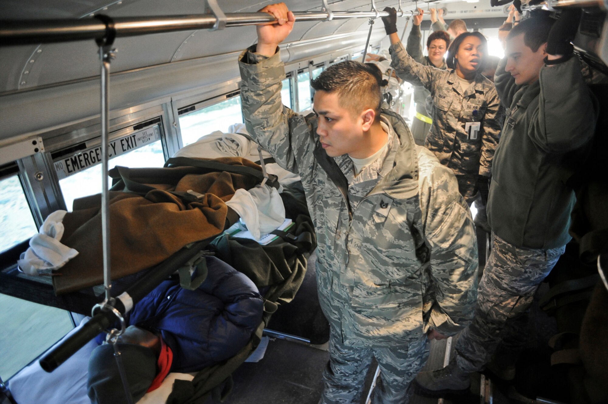 Air Force Tech. Sgt. Phillip Gabriel, 673d Medical Group, looks out the windows of an ambulatory bus transporting simulated natural disaster casualties during an evacuation drill as part of Mission Assurance Exercise 14-3 at Joint Base Elmendorf-Richardson, Alaska, March 31, 2014. MAE 14-3 is a JBER exercise testing the base’s ability to survive, operate and coordinate during a major natural disaster.   (U.S. Air Force photo/Justin Connaher)