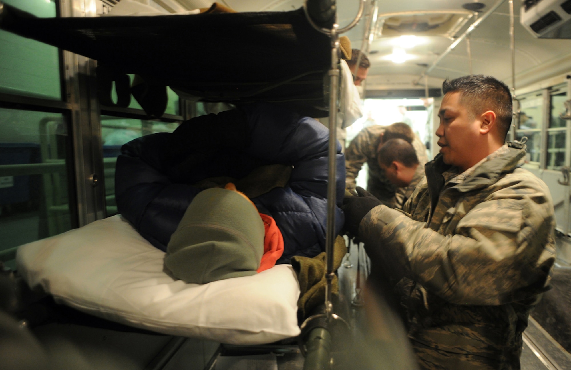 Air Force Tech. Sgt. Phillip Gabriel, 673d Medical Group, secures a simulated natural disaster casualty for transport in an ambulatory bus during an evacuation drill as part of Mission Assurance Exercise 14-3 at Joint Base Elmendorf-Richardson, Alaska, March 31, 2014. MAE 14-3 is a JBER exercise testing the base’s ability to survive, operate and coordinate during a major natural disaster.   (U.S. Air Force photo/Justin Connaher)