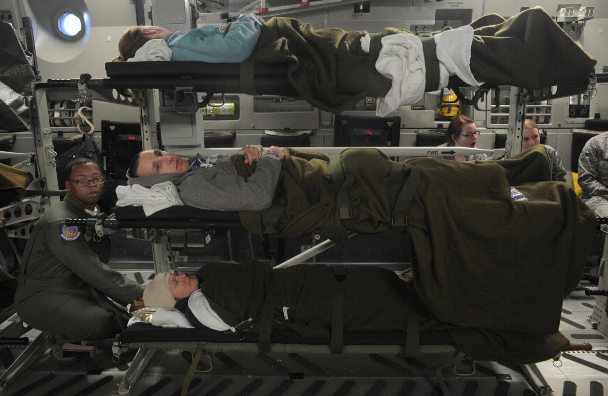 Air Force Staff Sgt. Errington Neysmith II, 375th Aeromedical Evacuation Squadron, prepares simulated natural disaster casualties for transport during an evacuation drill as part of Mission Assurance Exercise 14-3 at Joint Base Elmendorf-Richardson, Alaska, March 31, 2014. MAE 14-3 is a JBER exercise testing the base’s ability to survive, operate and coordinate during a major natural disaster.   (U.S. Air Force photo/Justin Connaher)